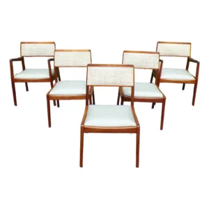 A set of mid-century dining armchairs in pale upholstery