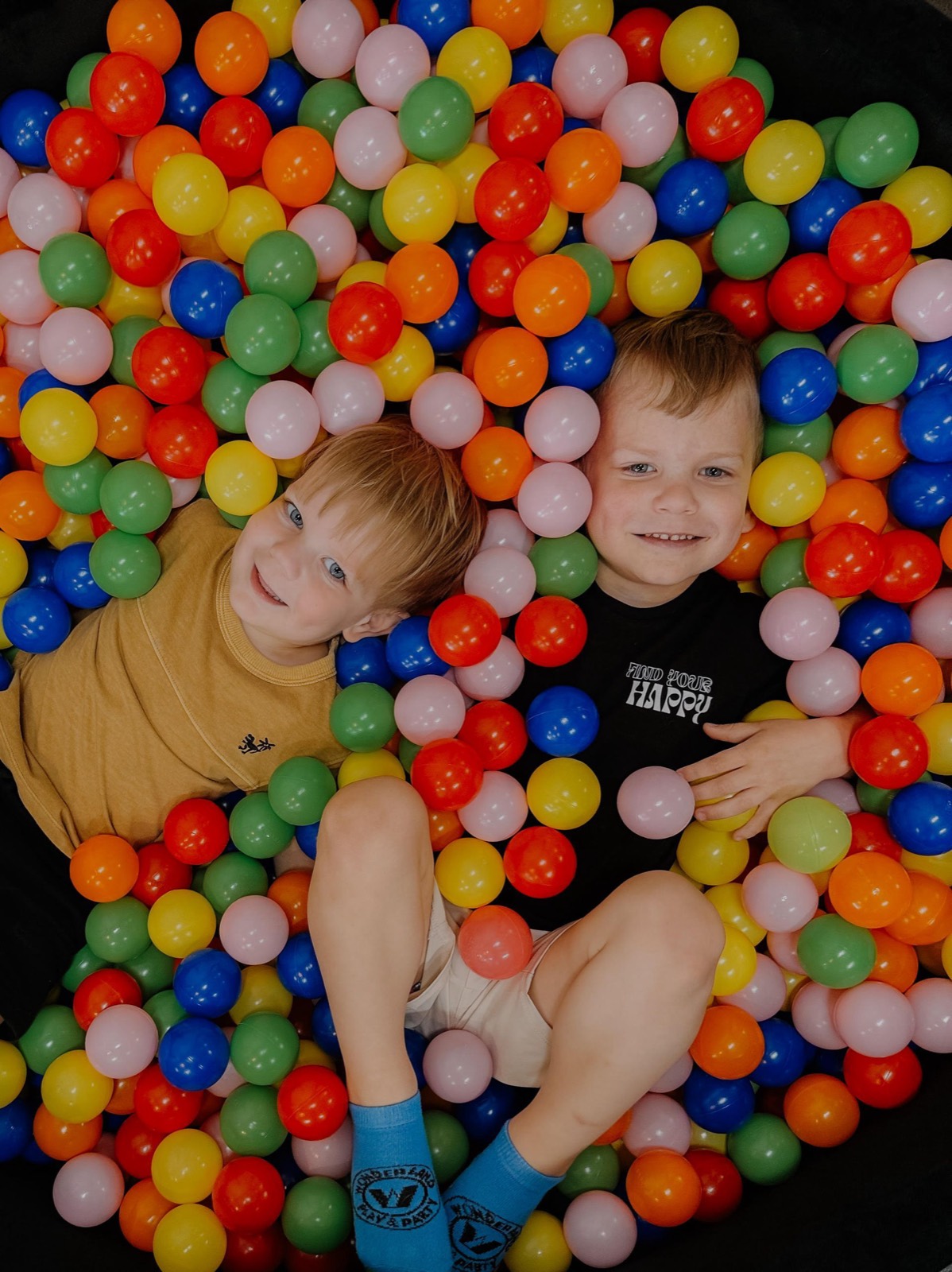 Two happy children playing in the colorful ball pit at Green Elephant Play