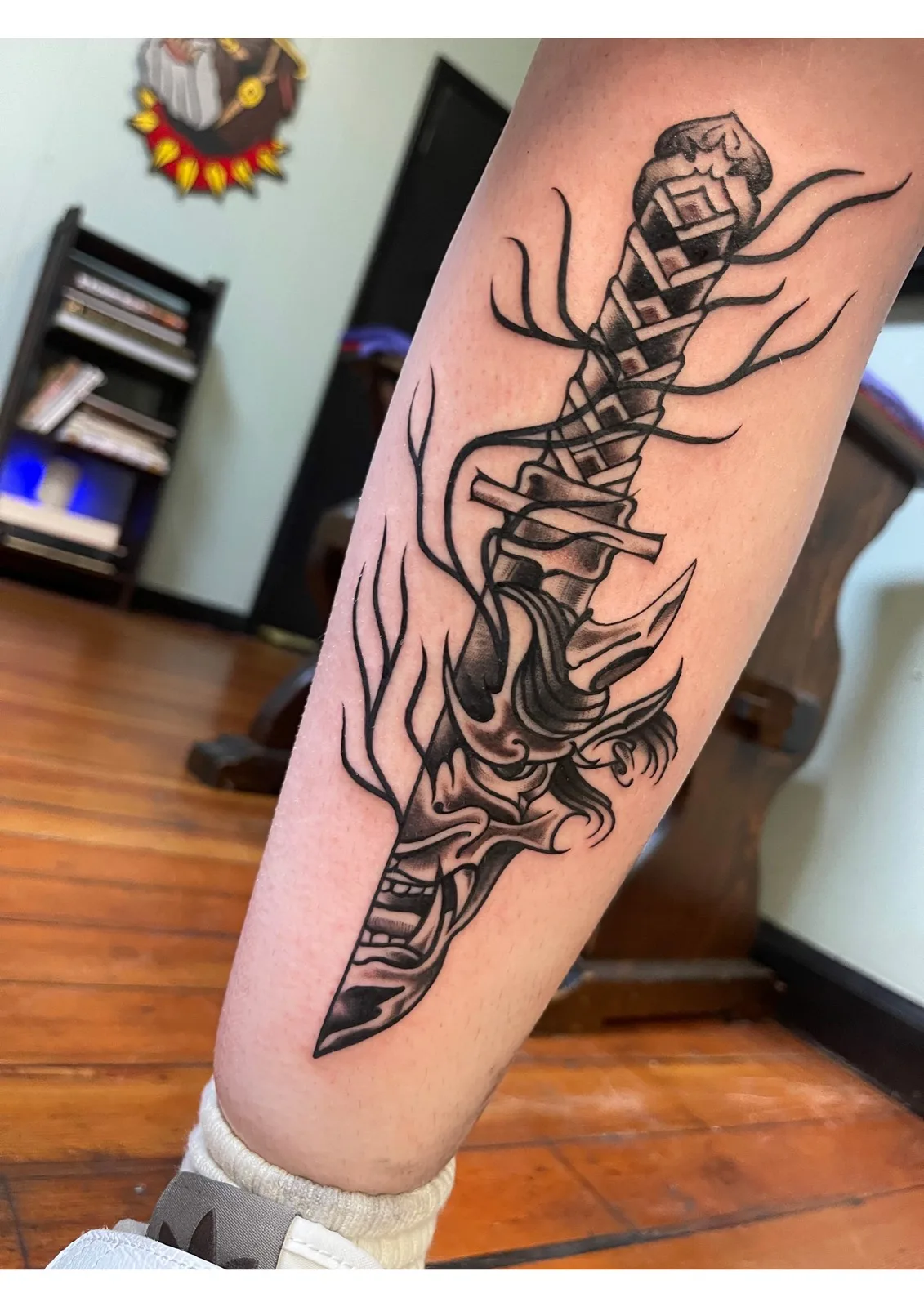 Black-and-grey dagger and hannya mask tattoo on a calf, Chicopee MA tattoo studio