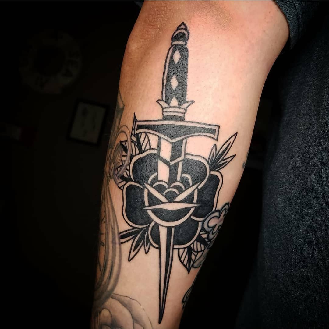 Black-and-grey dagger and rose tattoo