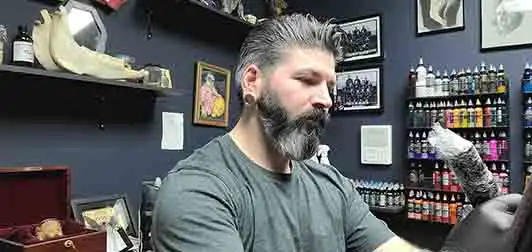 The artist at Studio 31 at his station, surrounded by inks and tools
