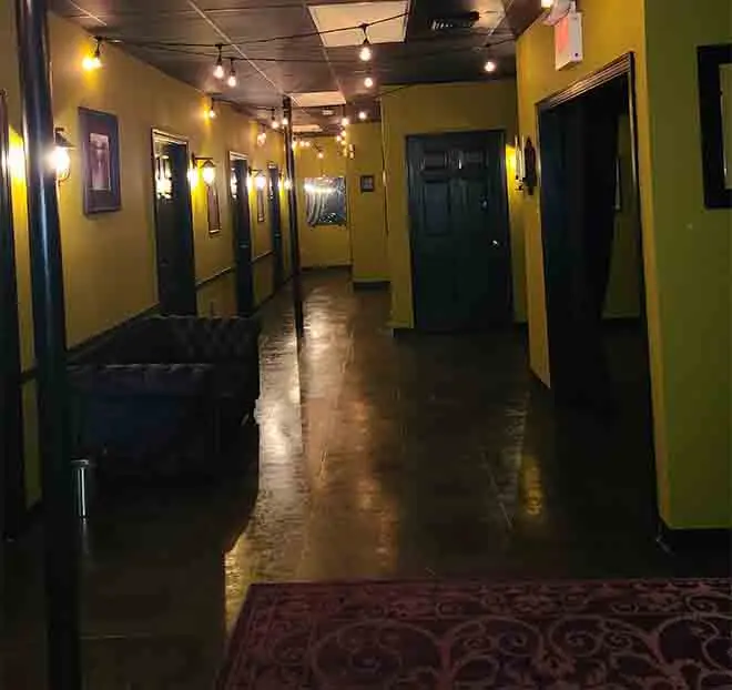 Inside Studio 31 — a warm, lamp-lit hallway with private rooms and framed art